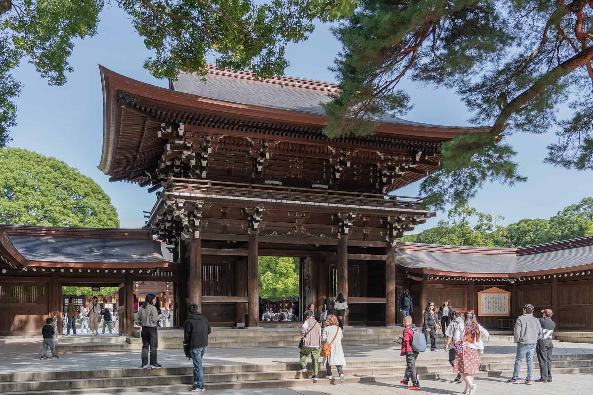 Meiji Jingu Shrine main gate in Tokyo Japan with traditional wooden architecture and visitors entering the sacred shrine grounds
