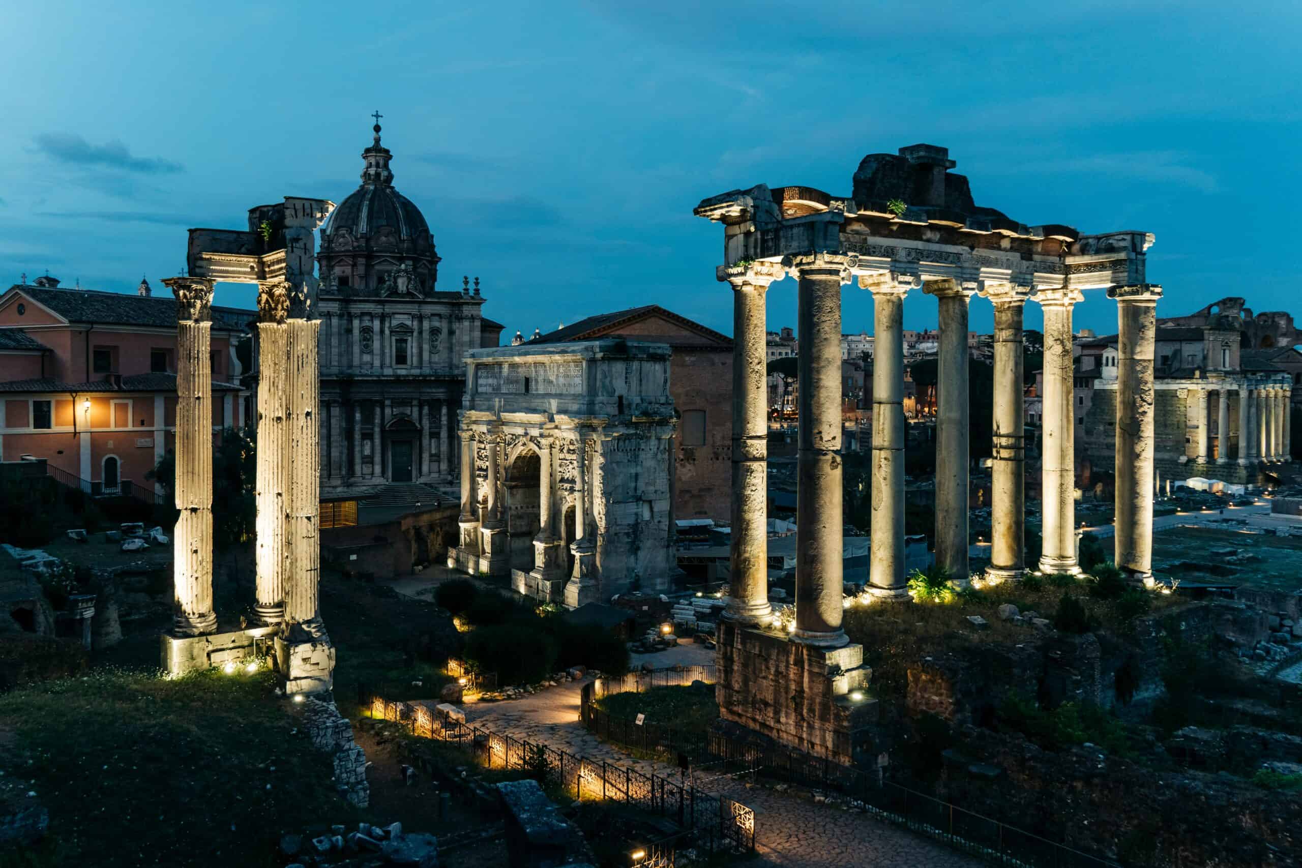 Roman Forum Rome at night with illuminated ancient columns and historic ruins