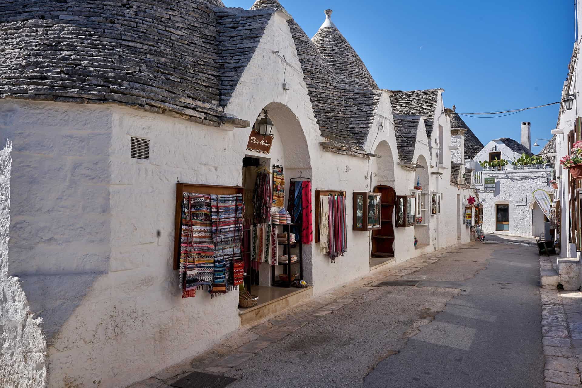 Alberobello Trulli street with traditional white stone houses and conical roofs in Puglia Italy