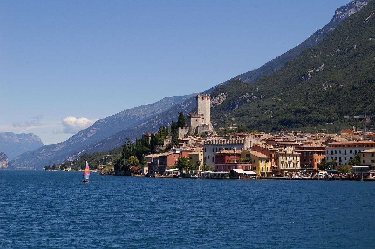 Sirmione Castle on Lake Garda with medieval towers, waterfront buildings, and mountain backdrop in northern Italy