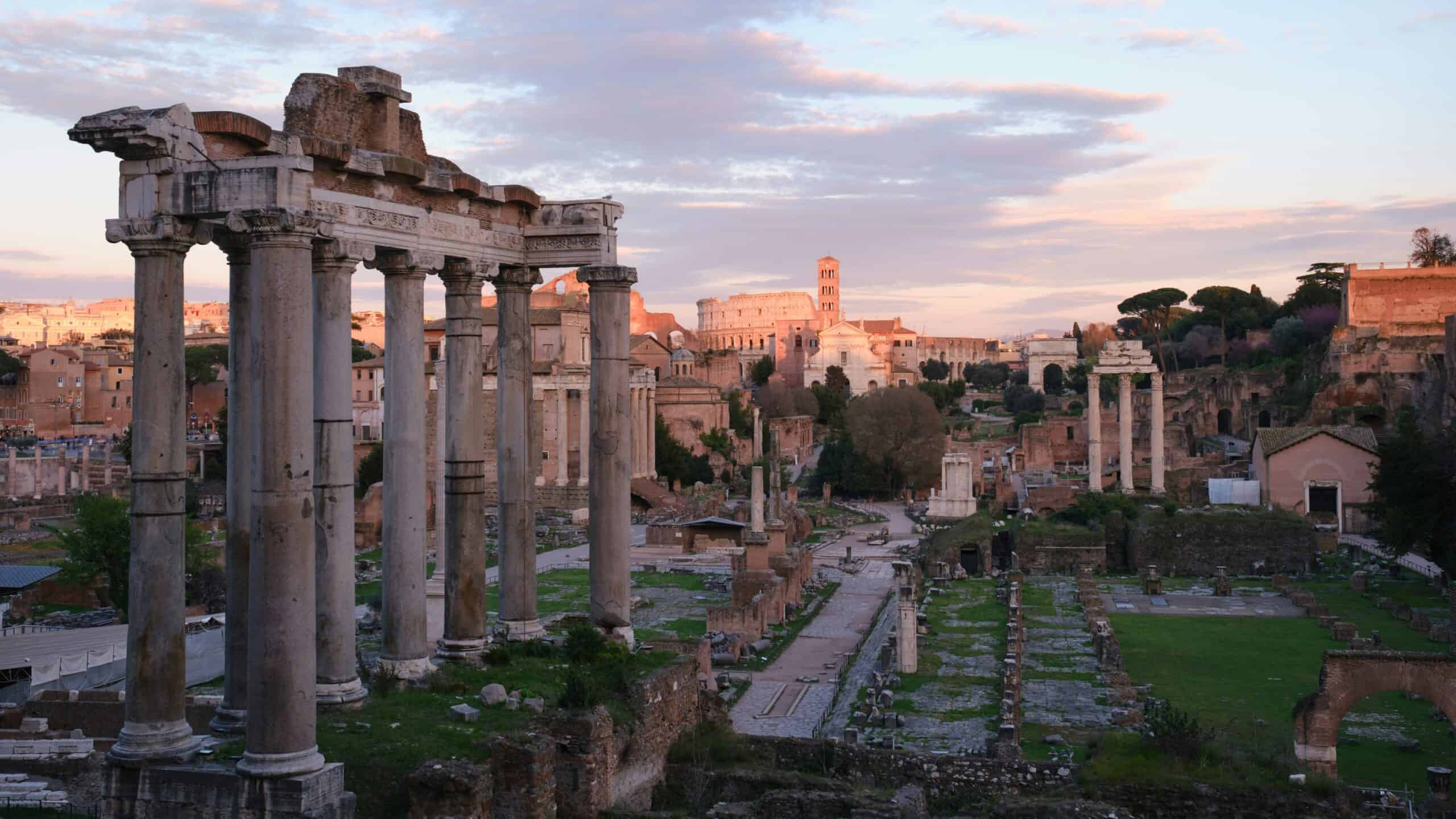 Roman Forum Rome ruins at sunset with ancient columns and Colosseum in the background