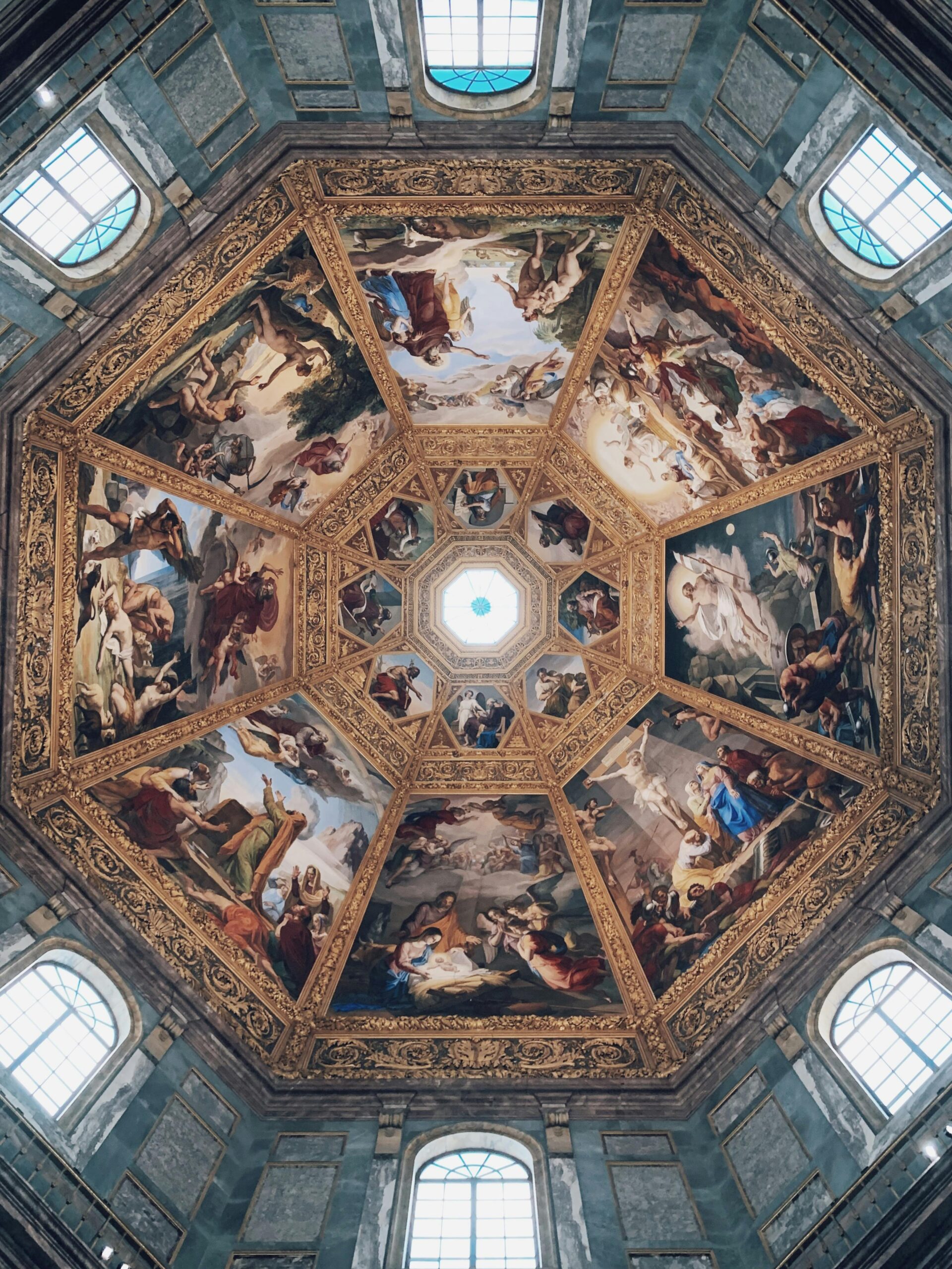 Detailed view of an ornate Renaissance ceiling with intricate frescoes in an Italian gallery.