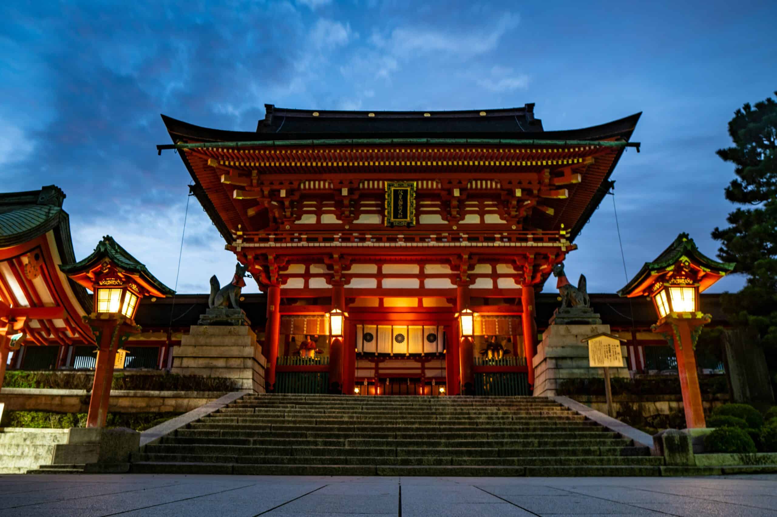 Fushimi Inari Shrine Romon Gate at dusk in Kyoto Japan with traditional lanterns and vermilion shrine architecture