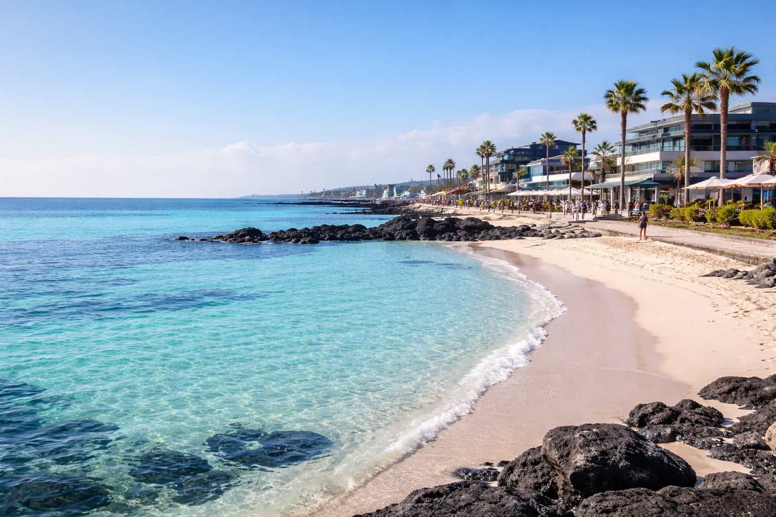 Woljeongri Beach in Jeju with white sand, emerald water, and a calm coastal promenade