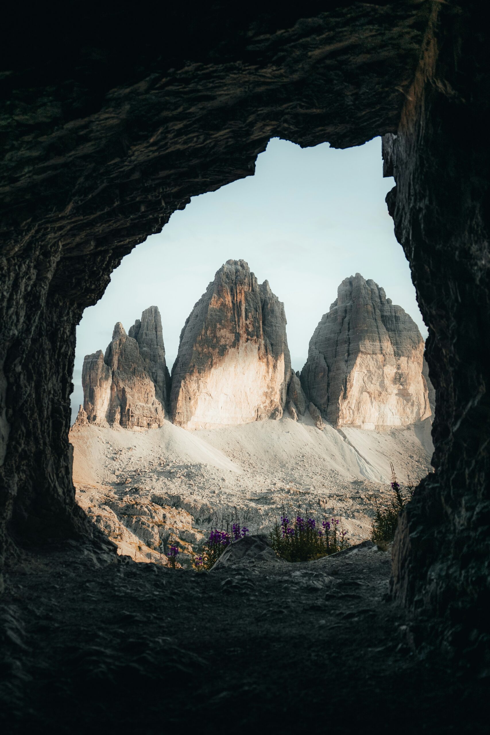 Dolomites Tre Cime di Lavaredo viewed from cave framing with dramatic limestone peaks in the Italian Alps