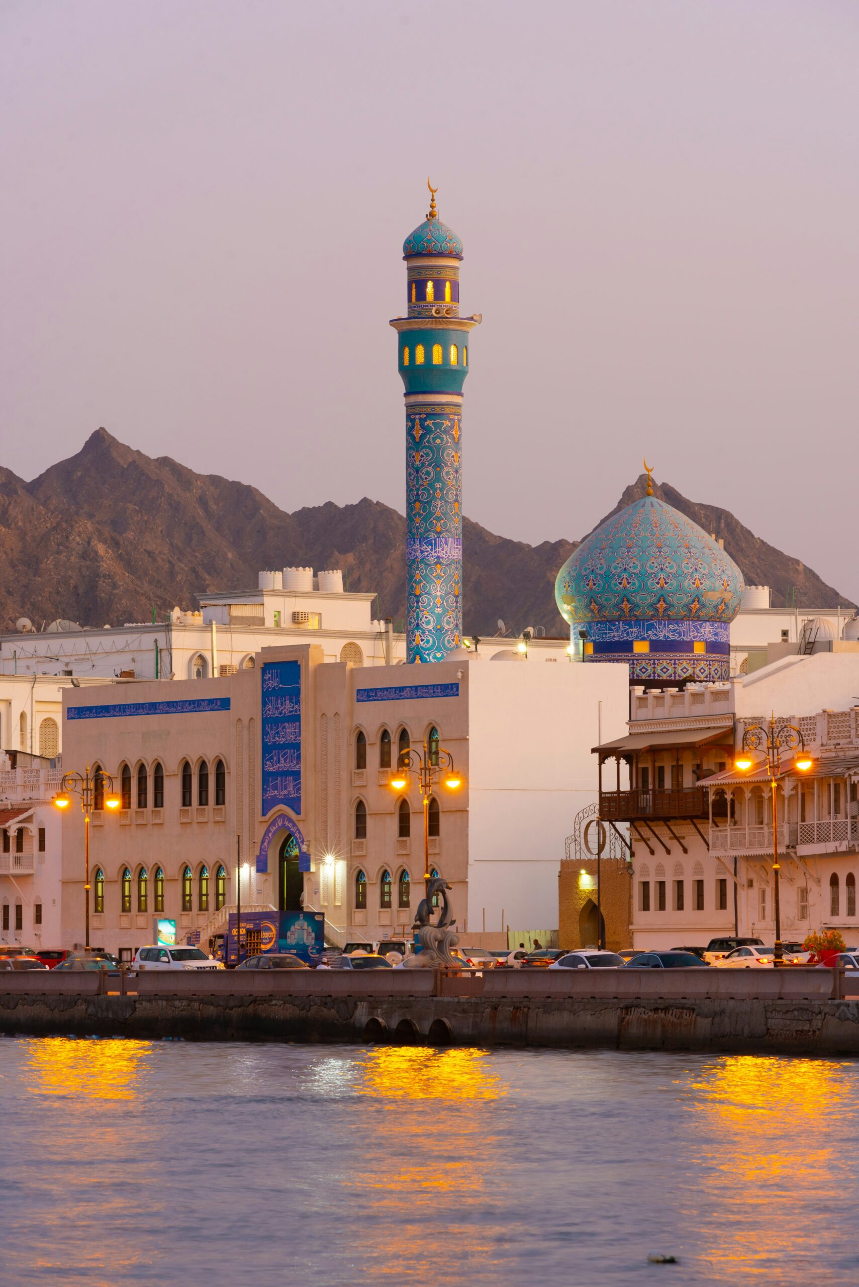 Oman Muscat mosque waterfront city view at sunset travel guide