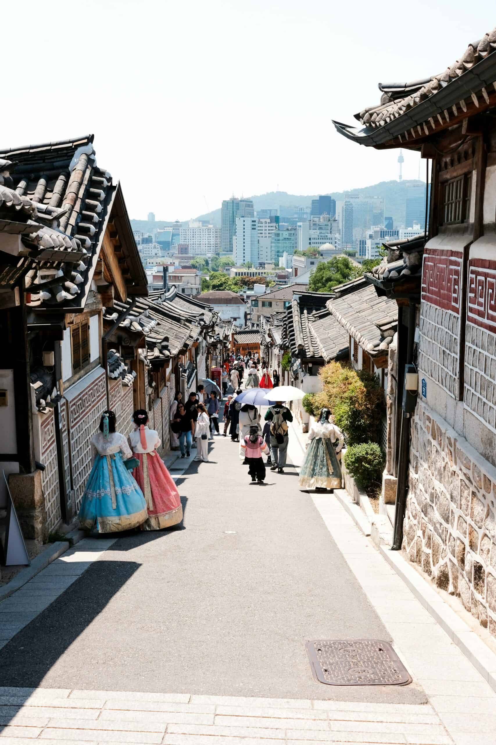 Bukchon Hanok Village traditional alley with hanok houses and visitors wearing hanbok in Seoul