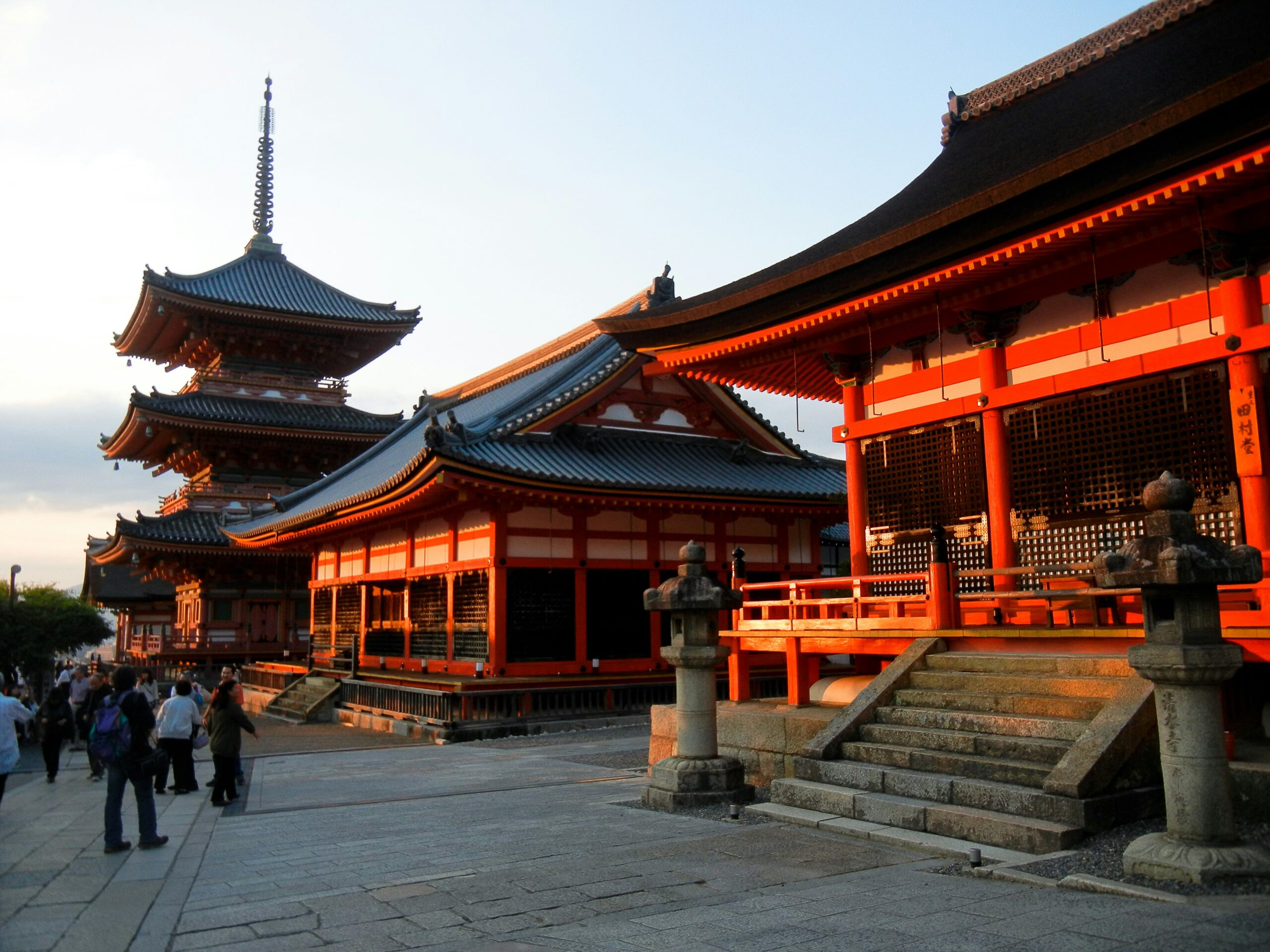 Kiyomizu-dera Temple main hall and pagoda in Kyoto during daytime with visitors walking along the historic complex