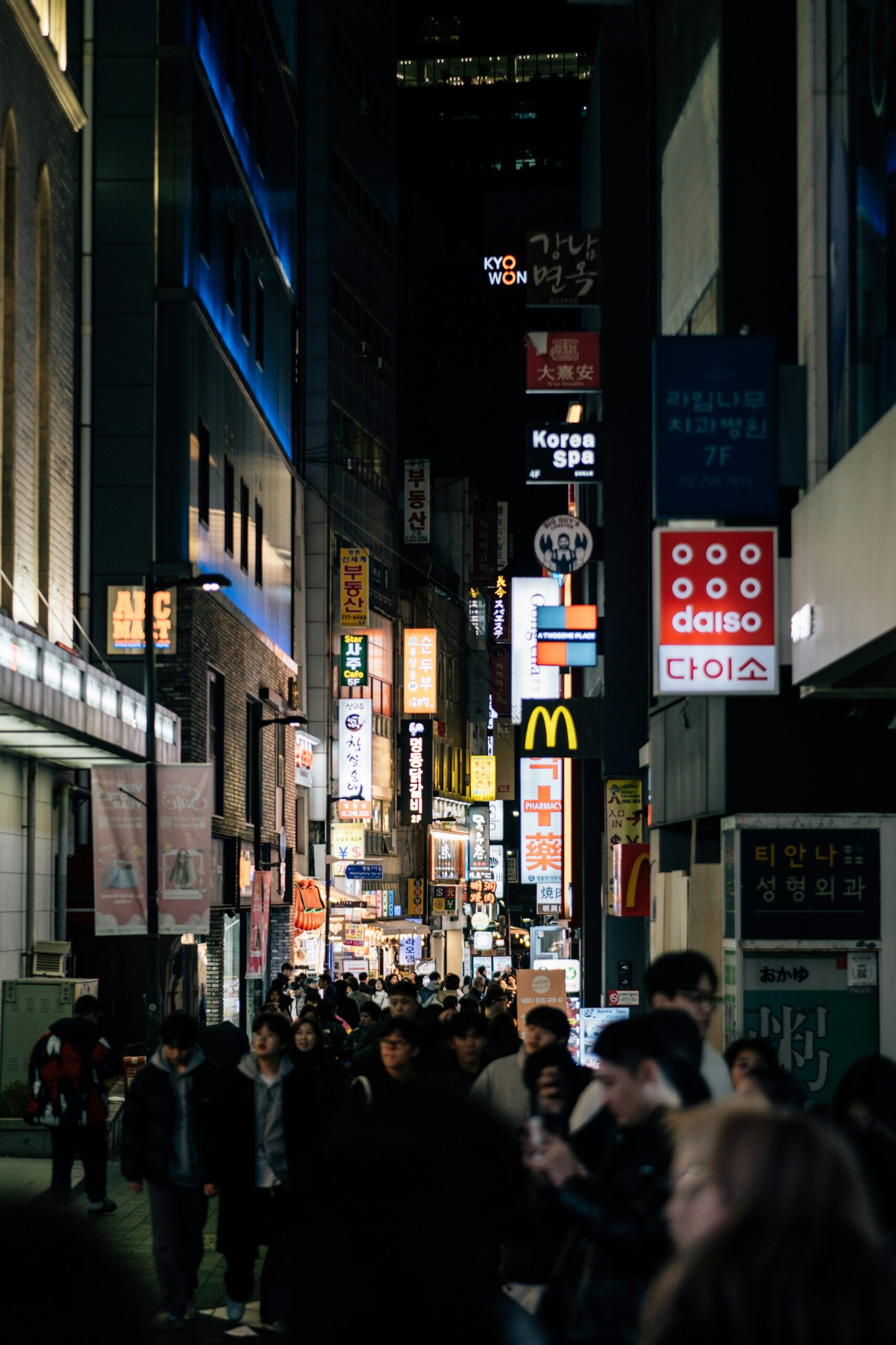 Crowded night street in Myeongdong Shopping Street with neon signs and shops in Seoul