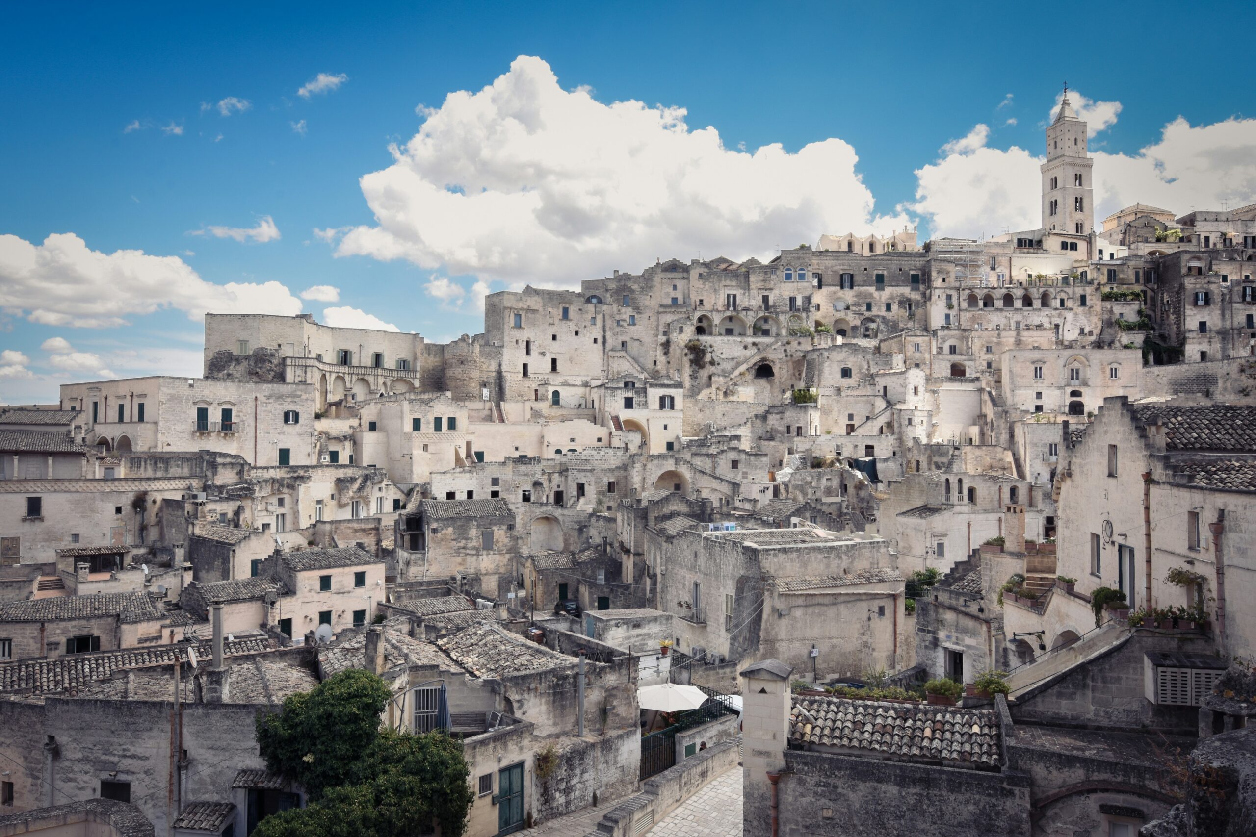 Matera Sassi panoramic view with historic stone cave dwellings under blue sky in Basilicata, Italy