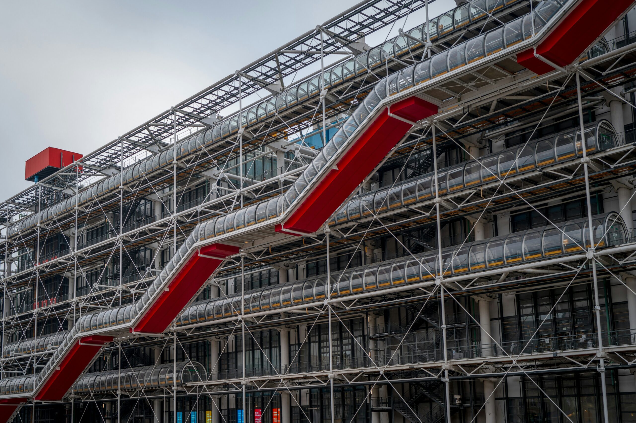 Exterior view of Centre Pompidou in Paris with colorful exposed pipes and the glass escalator tube.
