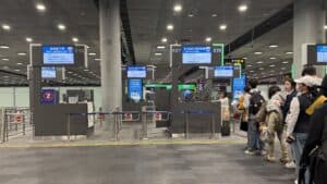 airport immigration checkpoint line with travelers waiting and passport control officers at international airport