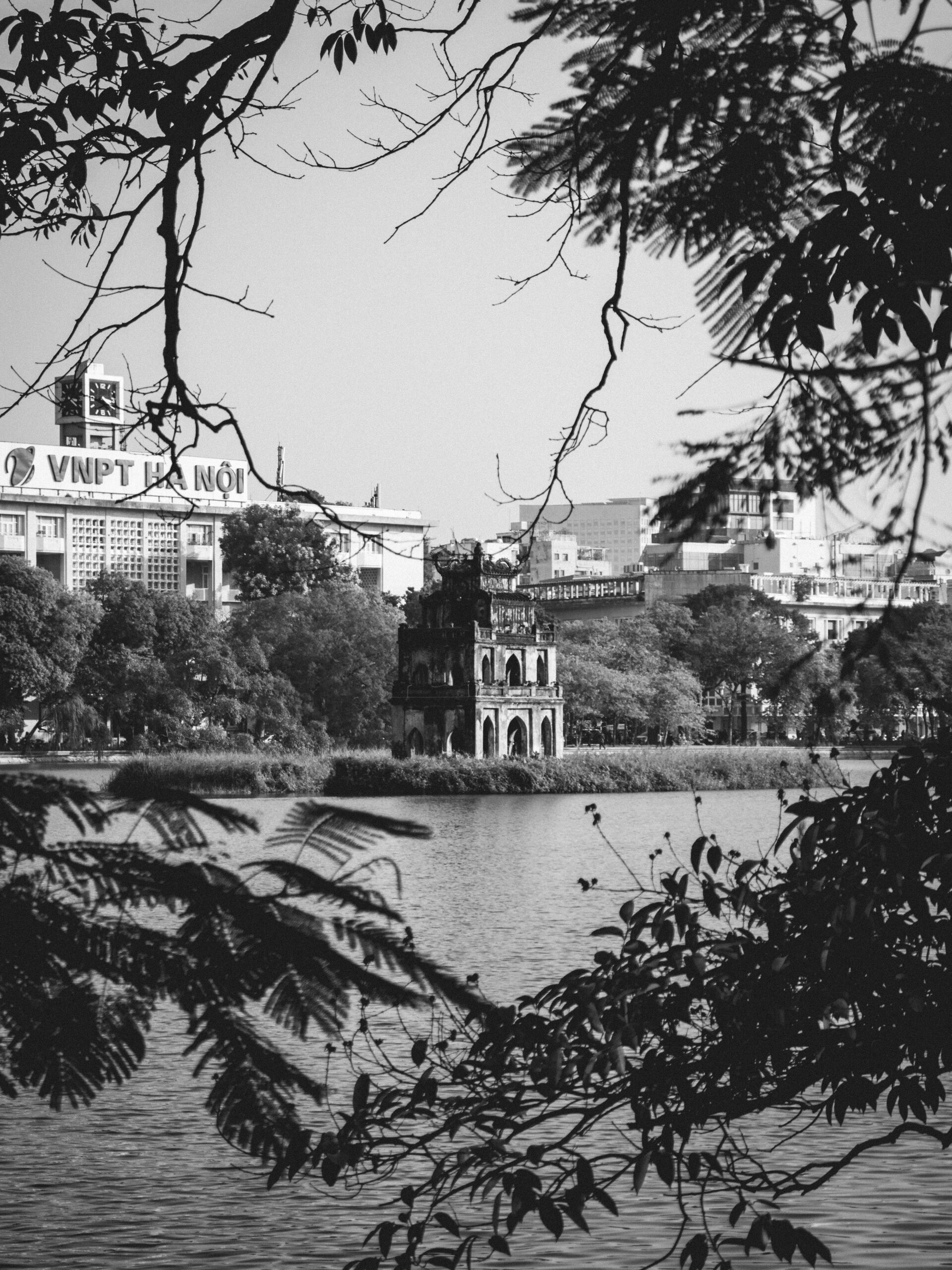 Hoan Kiem Lake Hanoi with Ngoc Son Temple framed by trees, peaceful morning view in Vietnam