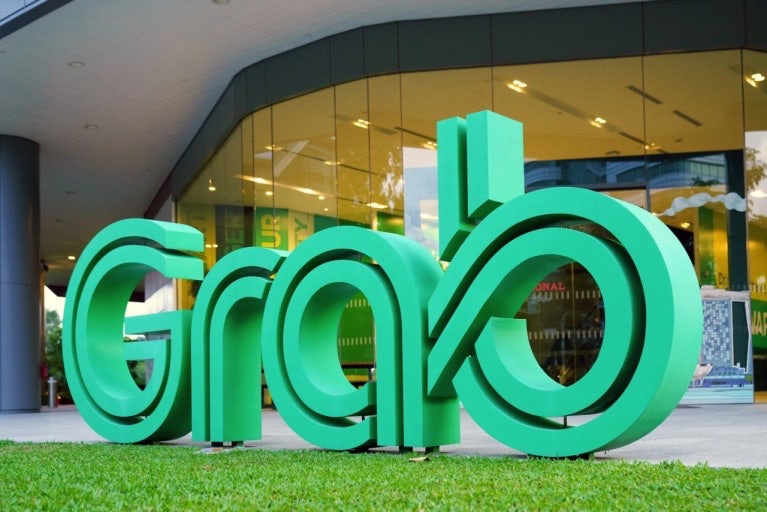 Grab logo sign in front of a building in Vietnam, commonly used ride-hailing app for travelers